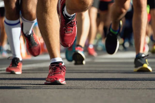 Close-up of distance runners' feet in running shoes during a road race
